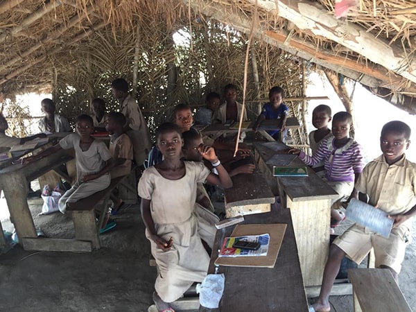 Group of children in a grass school hut