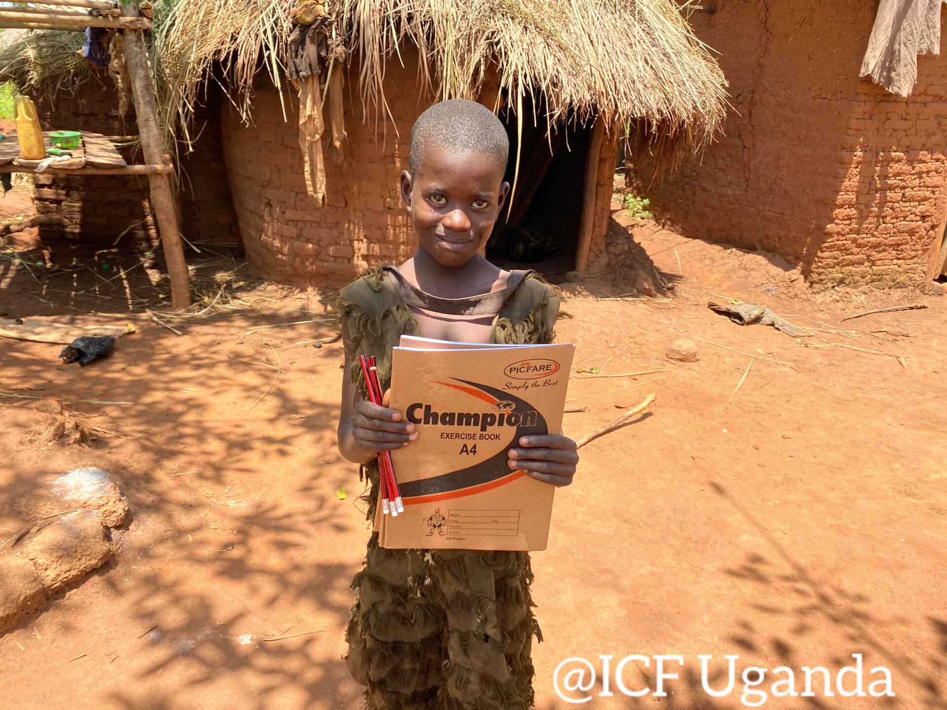Child getting a textbook in Uganda for education charity.