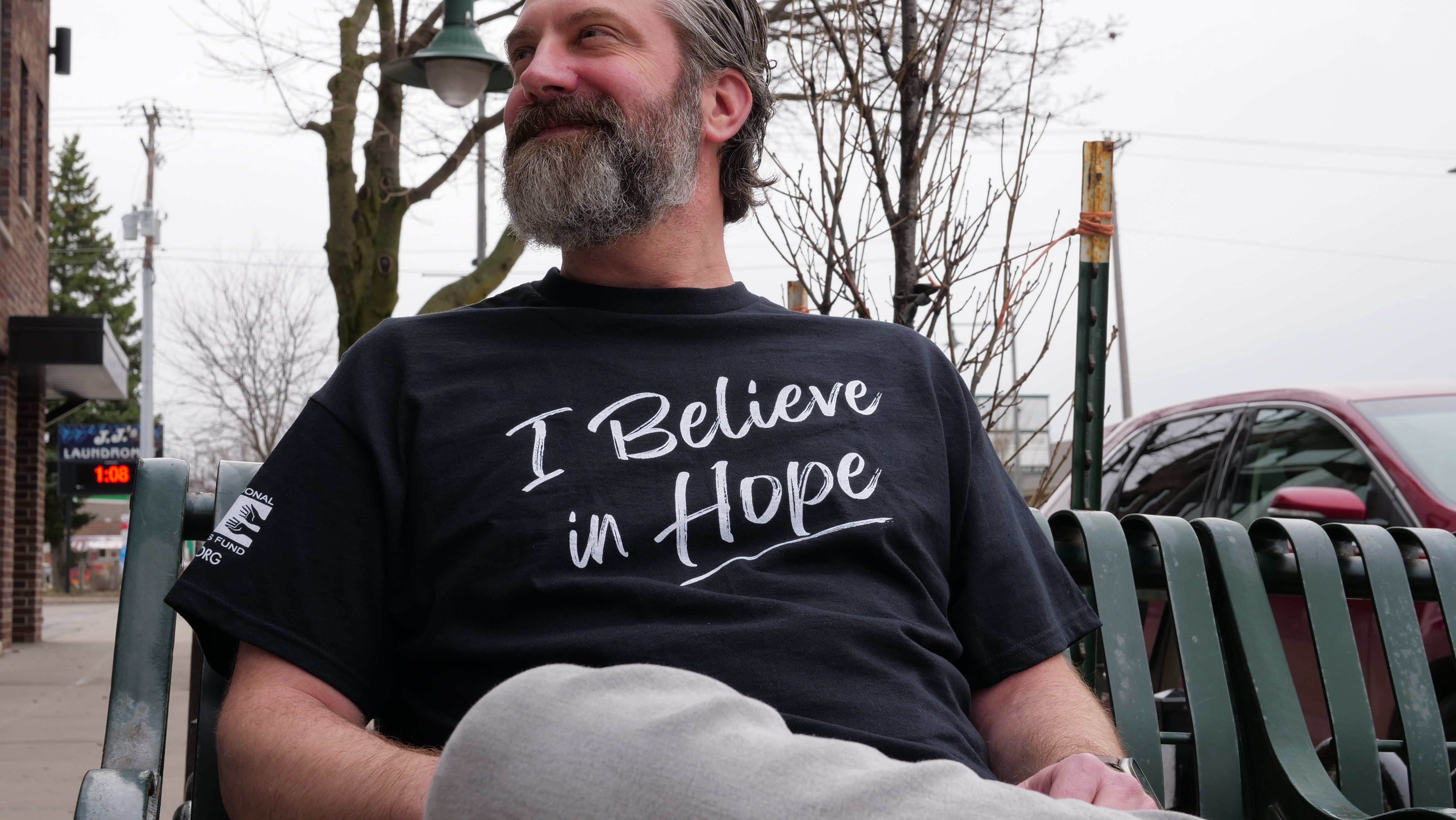 Man sitting on a bench wearing his ICF Hope shirt