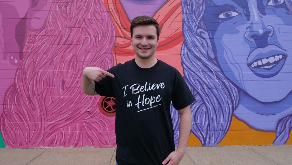 Hope shirt front side in front of street mural