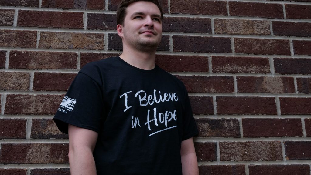 Man standing against a brick wall wearing an ICF Hope shirt